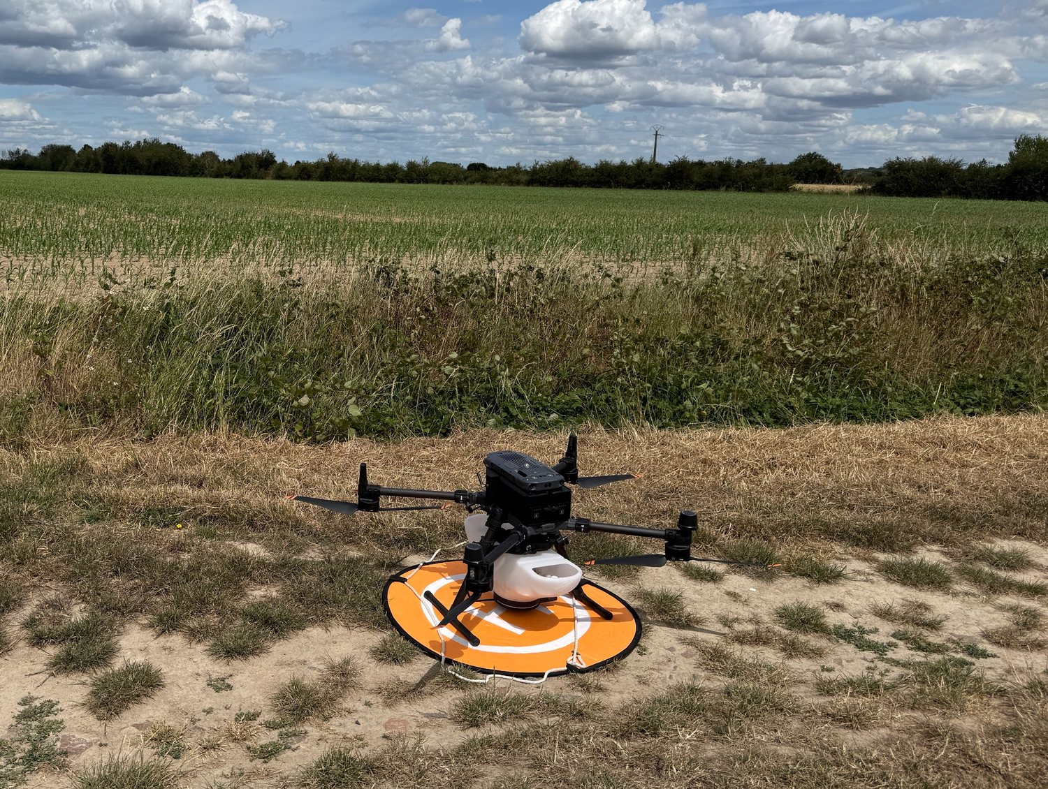 Drone agricole équipé pour une opération de largage de trichogrammes dans une parcelle.
